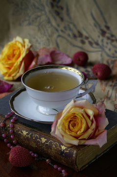 Tasse Tee mit frischen Rosen und Litschies