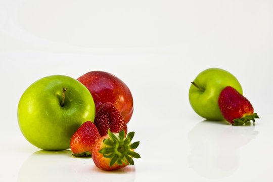 red and green apples and strawberries white background