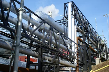 Crédence de cuisine en verre imprimé Bâtiment industriel industrial pipelines on pipe-bridge against blue sky