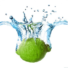 Fresh lime dropped into water with splash isolated on white
