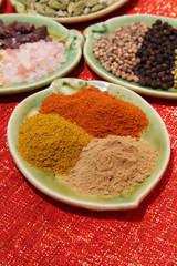 three piles of indian powder spice on plate