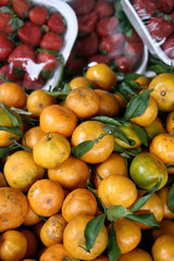 Tangerines; strawberries in background at a Philippine market