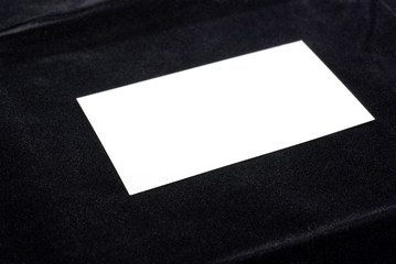 White business card isolated on black velvet background.