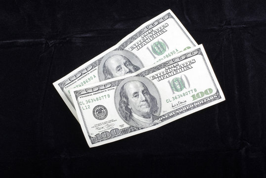Two hundred dollars banknotes isolated on black velvet backgroun