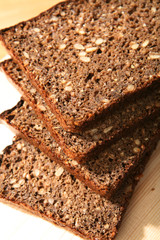 Slices of rye-bread on wood surface.