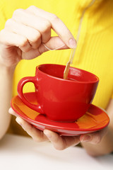 Red cup in female hands.