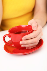 Red cup in female hands.