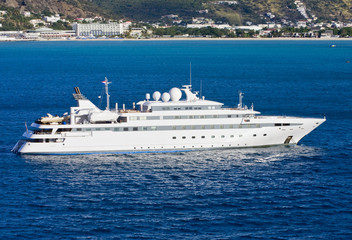 Fototapeta na wymiar Large White Yacht in Blue Bay