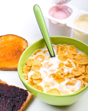 bowl of cereal with toasts spread with jam and yougurt