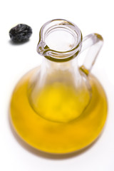 olive oil bottle top with a black olive at background