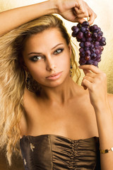 Beautiful young sexy woman with a grape