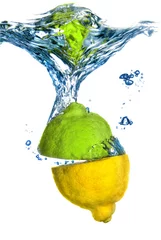 Poster lemon and lime dropped into water with bubbles isolated on white © artjazz