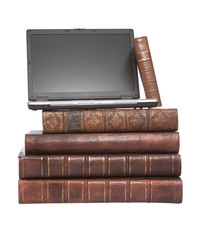 Old leather bound books with a laptop