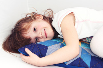 Little girl on a colorful pillow