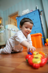 infant plays on floor, soft focus