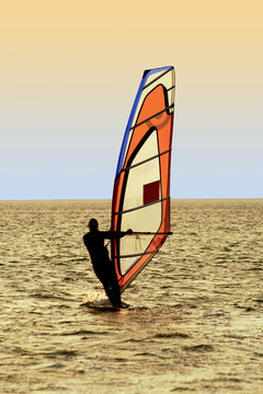 Silhouette of a windsurfer on waves of a sea