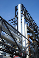 industrial pipelines and smokestack against blue sky