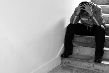 Frustrated man sitting on steps, black and white picture