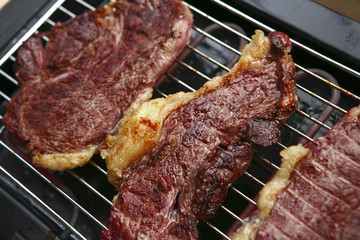 three roast steak on electrical brazier