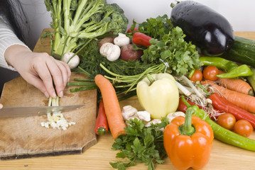 Close up woman cutting vegetables in kitchen