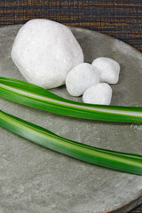 Weiße Steine auf Teller mit grünen Blättern