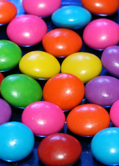 A pile of chocolate candies with a colorful outer shell