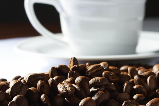 Fototapeta Cup with coffee, costing on coffee grain
