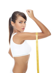 Young beautiful woman with measure tape on white