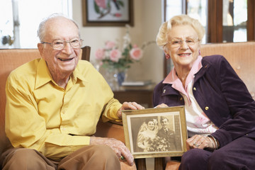 Senior couple holding wedding photo