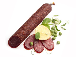 Smoked salami decorated with lemon and green pea