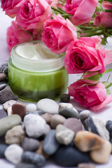 Fototapeta na wymiar roses, pebbles and cream - natural cosmetics
