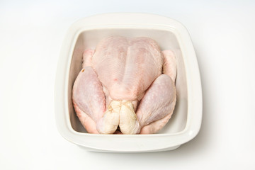 Whole raw chicken isolated on a white studio background.