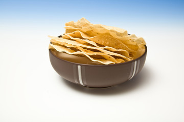 bowl of Pappadums on a blue studio background.