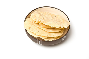 bowl of Pappadoms isolated on a white studio background.