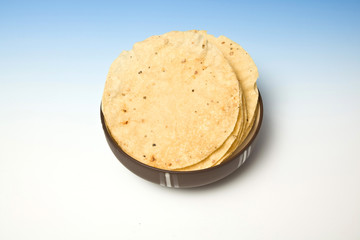 bowl of Pappadoms on a blue studio background.
