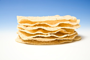 Pappadums on a blue studio background.