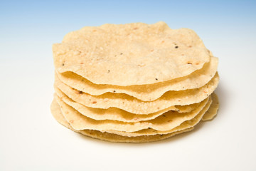 Pappadums on a blue studio background.