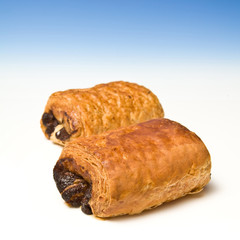 Chocolate crossant on a blue studio background.