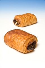 Chocolate crossaint on a blue studio background.