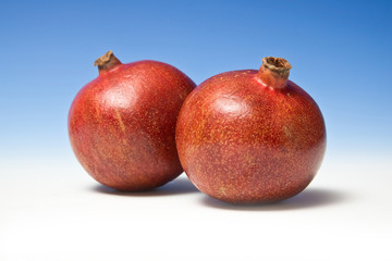 Pomegranates on a blue studio background.