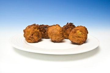 Onion Bhaji's on a blue studio background.