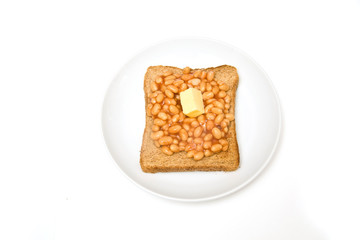 Plate of baked beans on toast, isolated on a white background.
