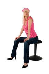 blonde in a pink blouse and blue jeans on a chair