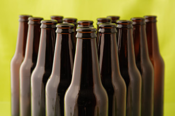 Empty beer bottles in front of a bright green background