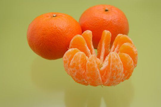 Orange mandarins on green background