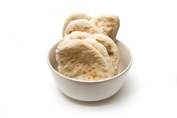 Bowl of pitta bread isolated on a white studio background.