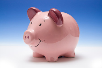 Piggy bank style money box on a blue studio background.