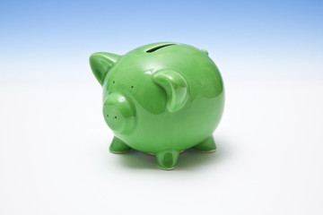 Piggy bank style money box on a blue studio background.