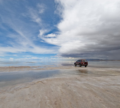 jeep in the salt lake salar de uyuni, bolivia