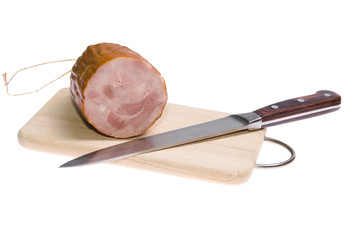 ham with knife on wooden cutting board
